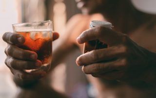 man drinking alcohol with cellulitis medication in hand