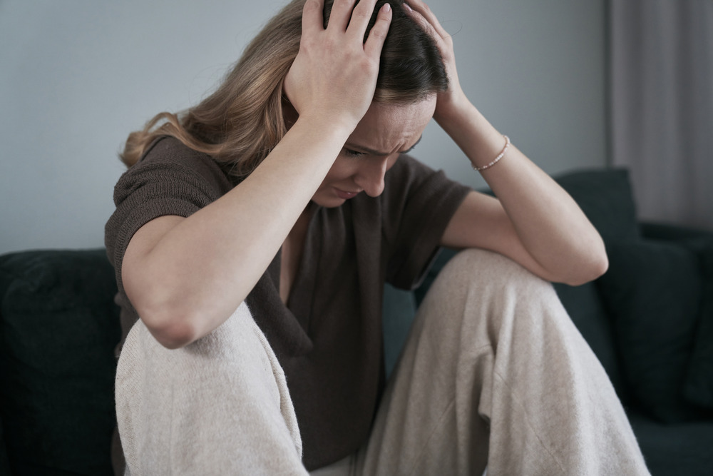 woman experiencing psychosomatic symptoms from mental health issues, young adult needs therapy for young adults
