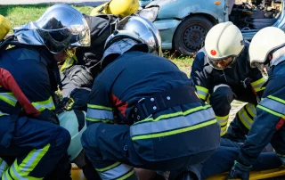 group of firemen surrounding person on stretcher