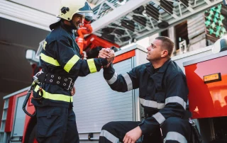 two first responders smiling and showing support for one another
