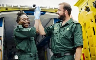 two paramedics high-fiving each other